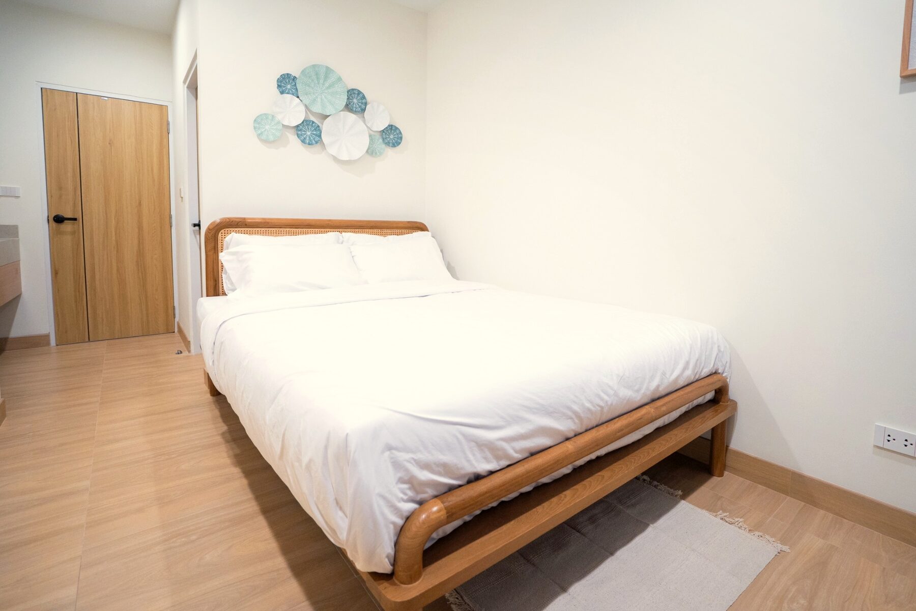 Calm bedroom with warm timber detailing in a SandScape villa